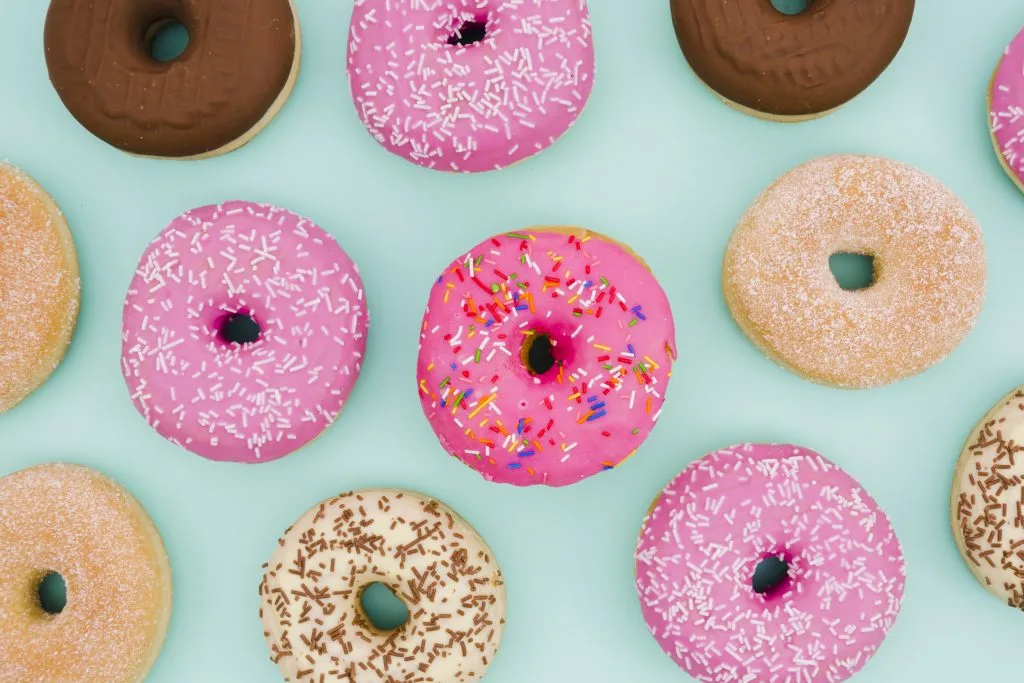 donuts com coberturas coloridas com um fundo azul 