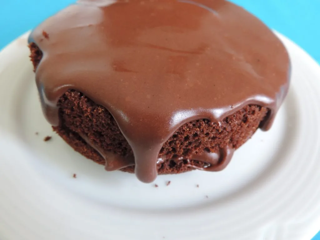 bolo de chocolate fit com cobertura, sobre um prato, com um fundo azul