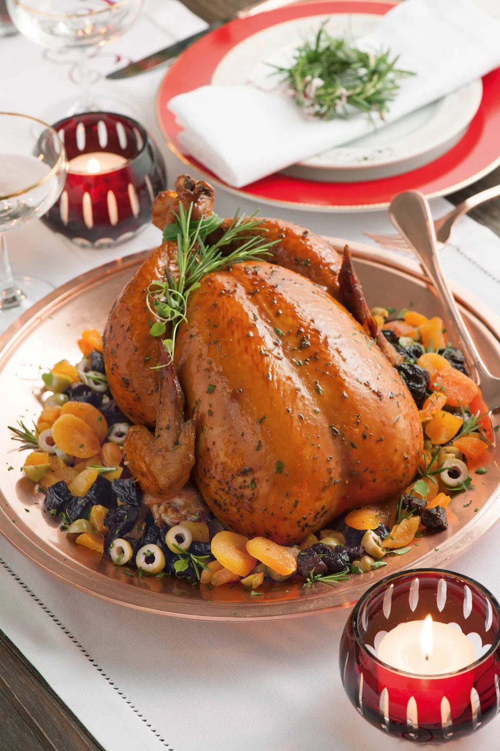 frango recheado sobre um prato na cor salmão em uma mesa decora com tema natalino