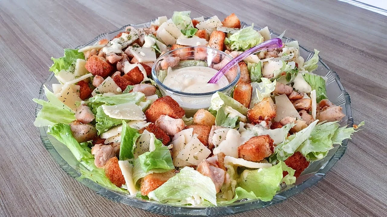 salada caesar em um refratário sobre uma mesa de madeira