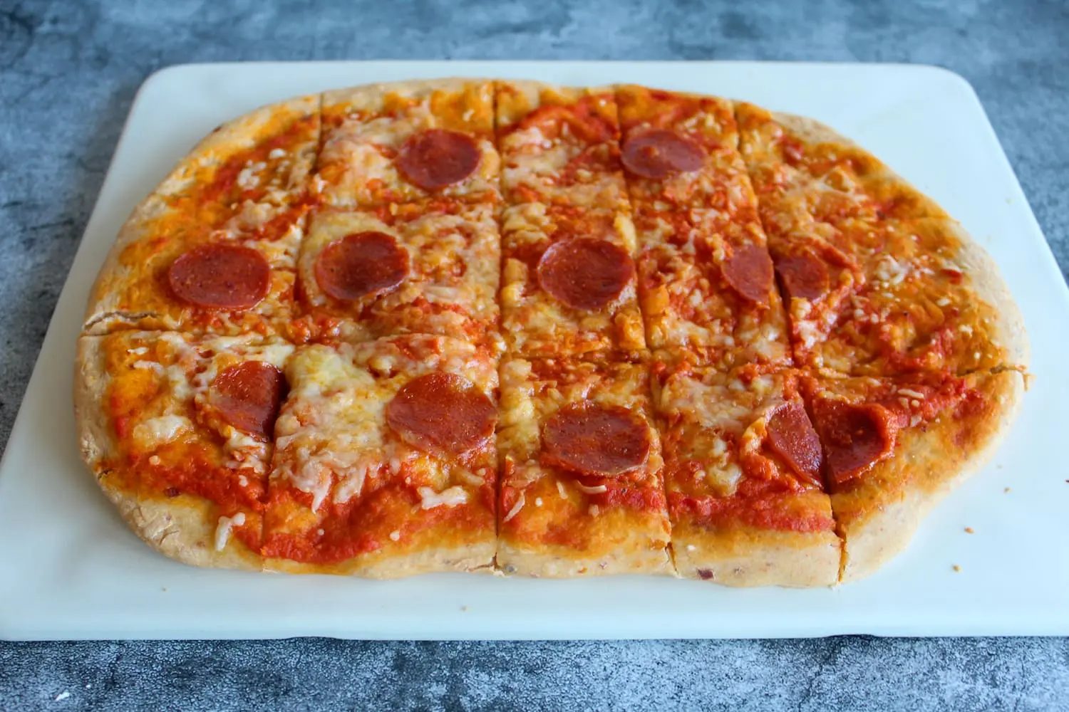 pizza de calabresa com tomate seco sobre uma tabua de corte