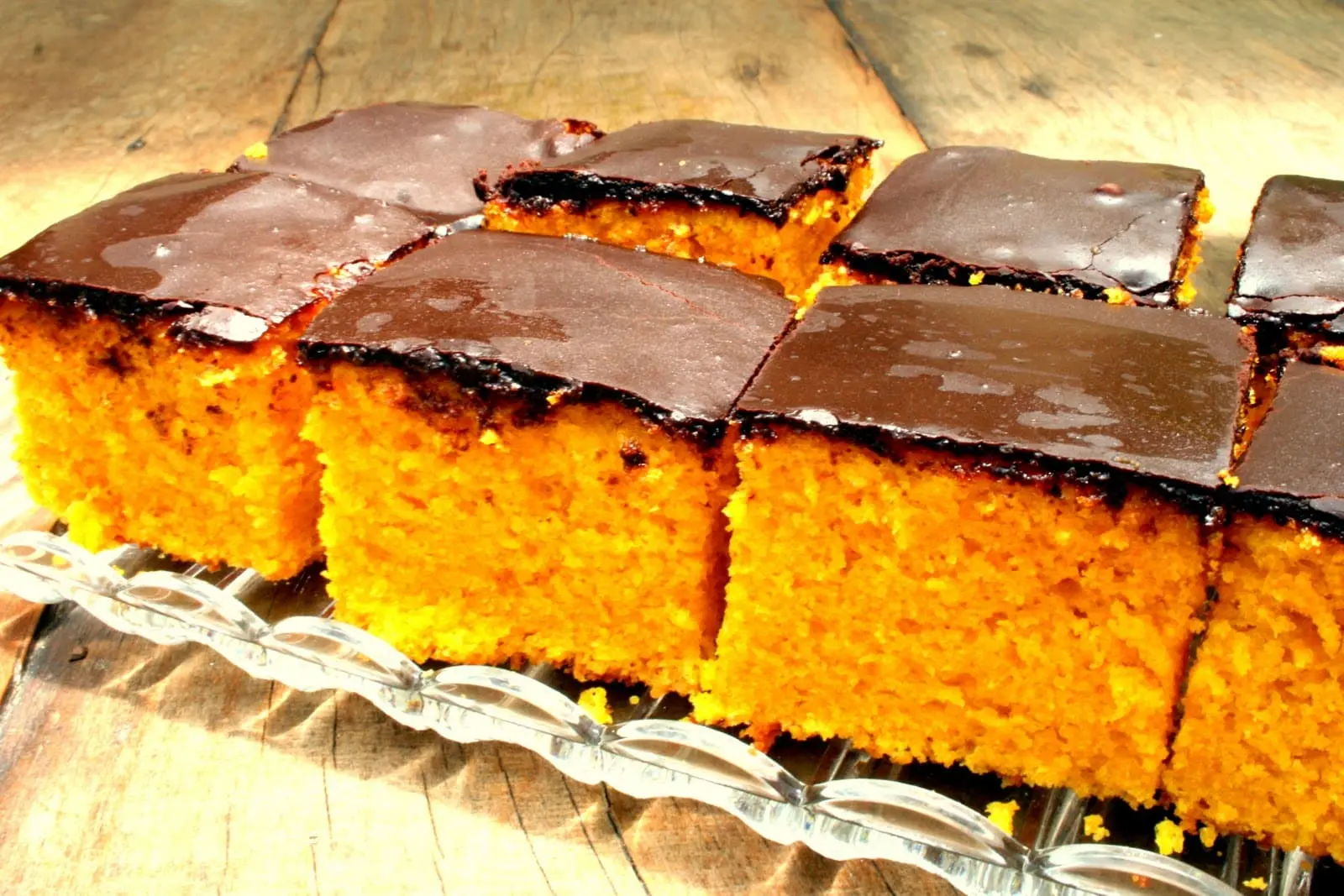 bolo de cenoura com cobertura de chocolate, cortado em quadrados em uma travessa