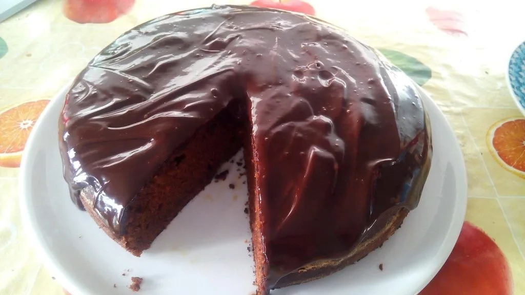 Bolo de Chocolate com cobertura de chocolate sobre um prato branco