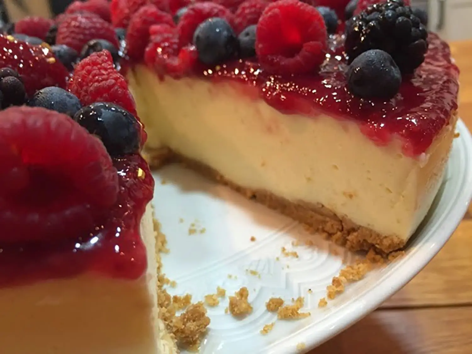 cheesecake em um prato branco sobre uma mesa de madeira