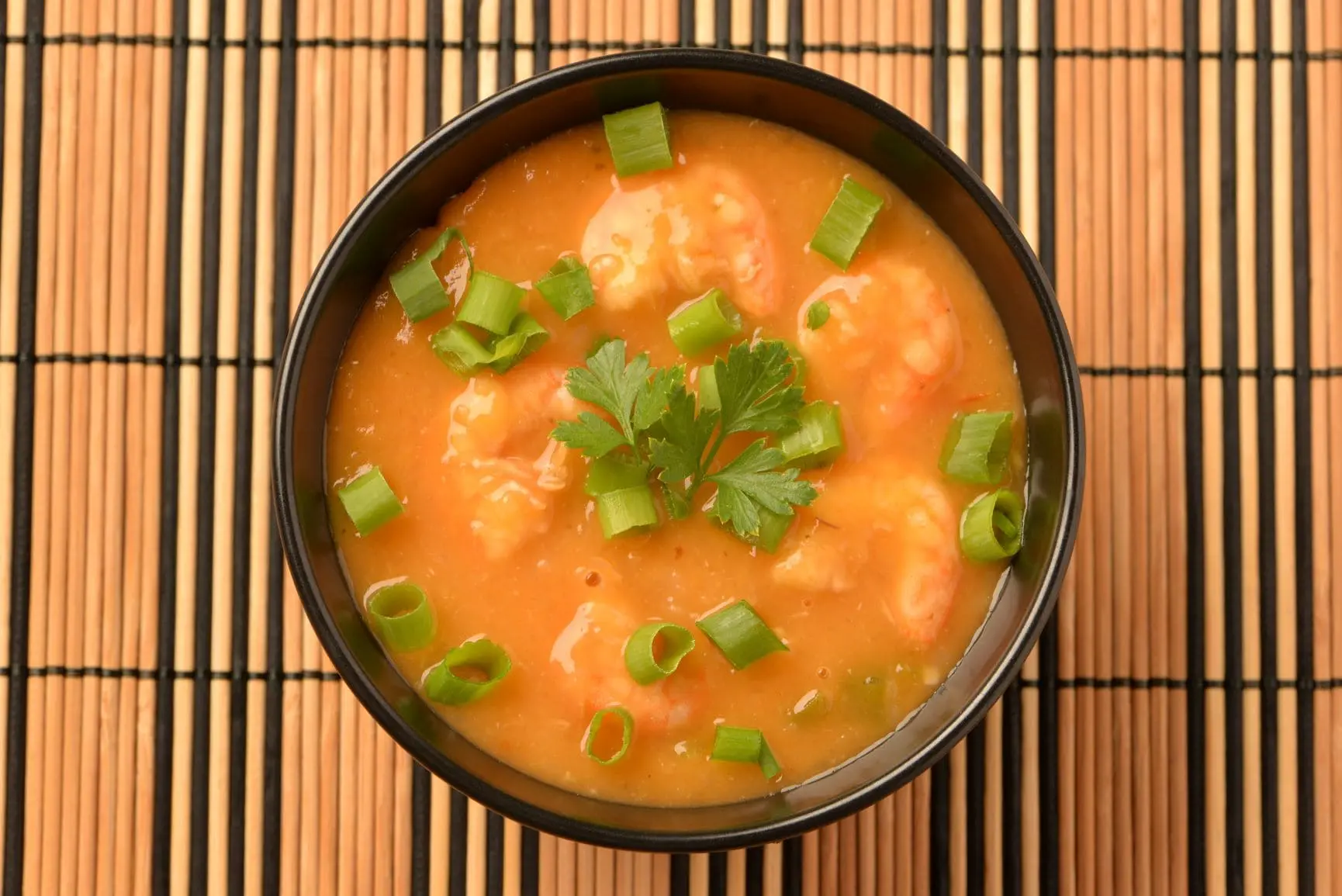 Sopa de peixe em uma tigela sobre uma esteira de bambu