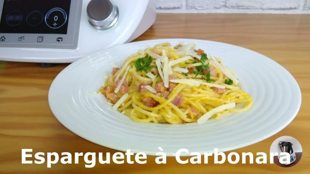 um prato com esparguete á carbonara
com uma bimby ao fundo 