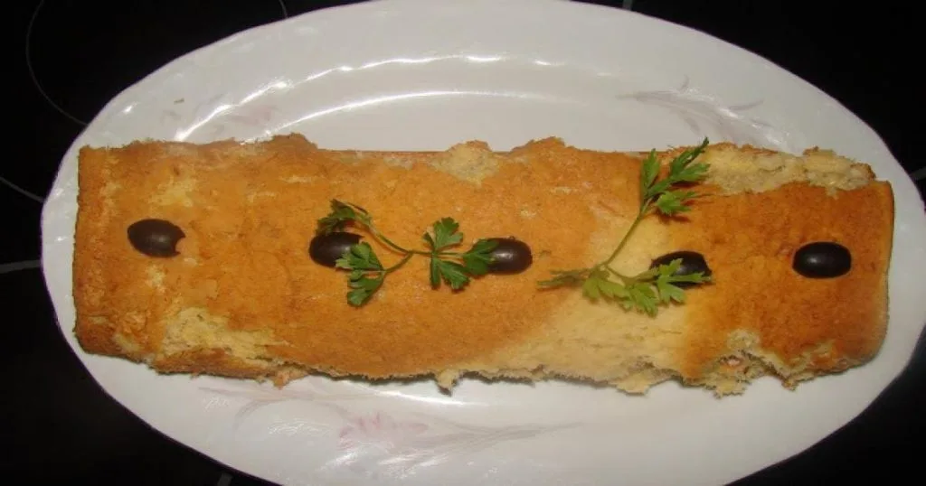 Torta de Bacalhau em formato de rolo sobre um prato branco 