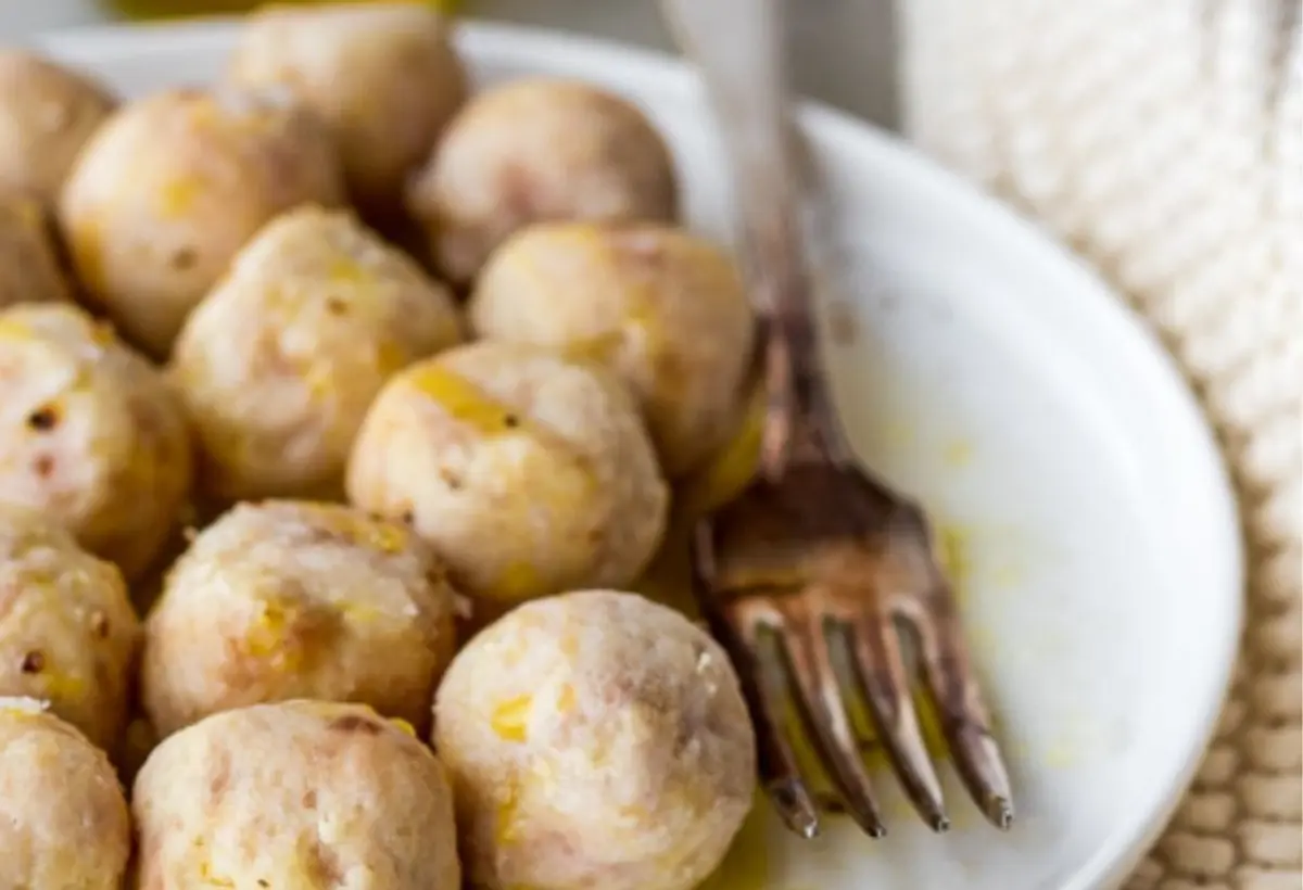 bolinhos em um prato na cor branca com um garfo ao lado