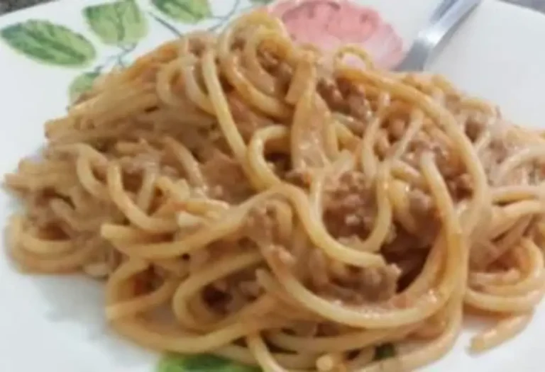 macarronada em um prato branco com desenhos de flores