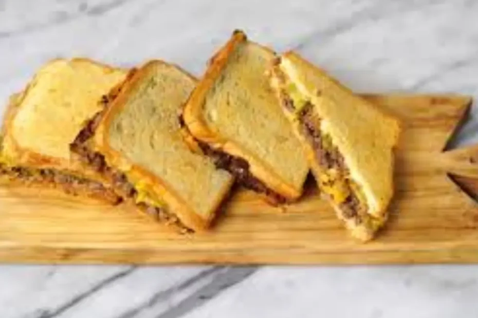 pães com recheio de carne moída sobre uma tabua de corte