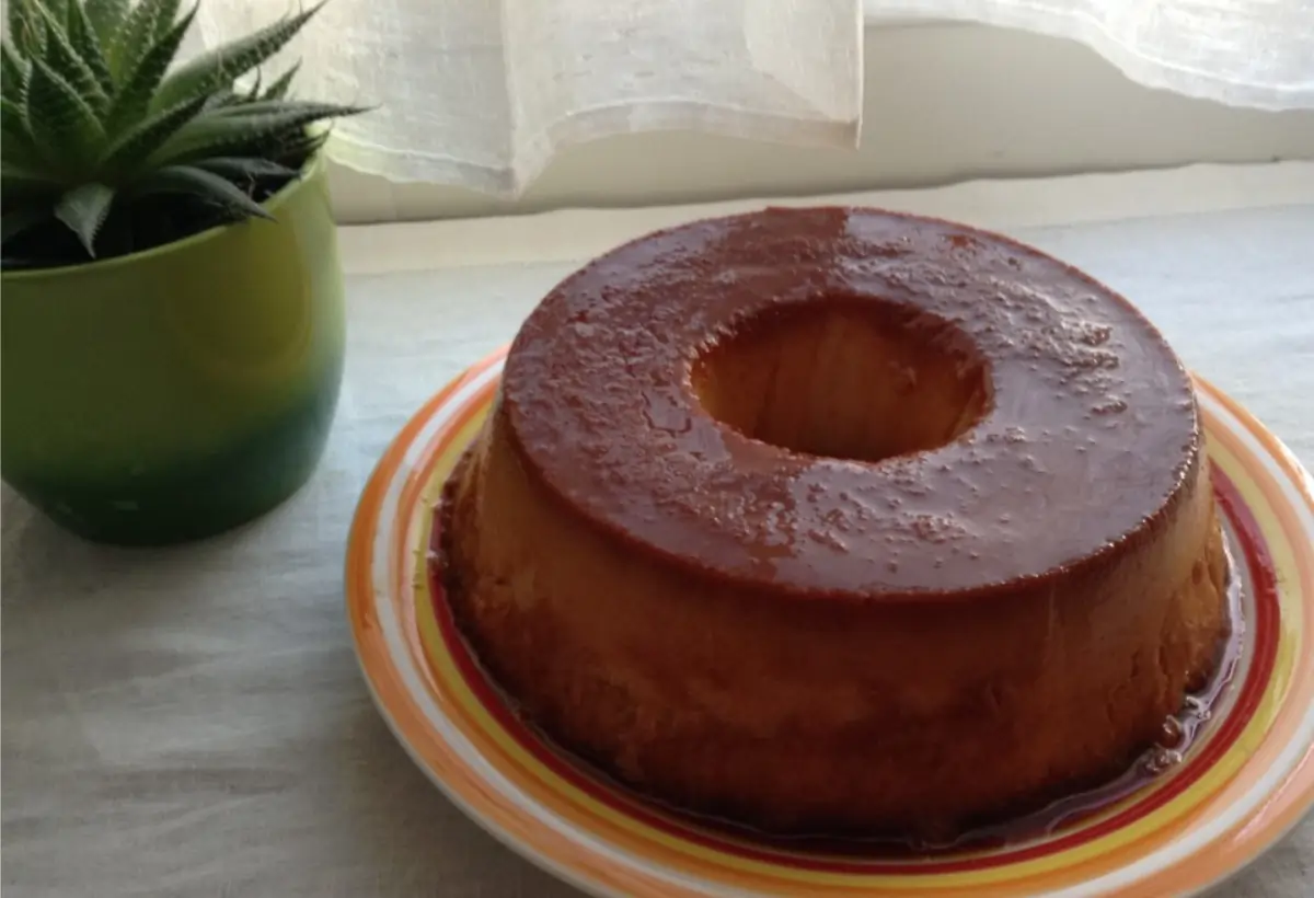 pudim de pão sobre um prato nas cores laranja e branco